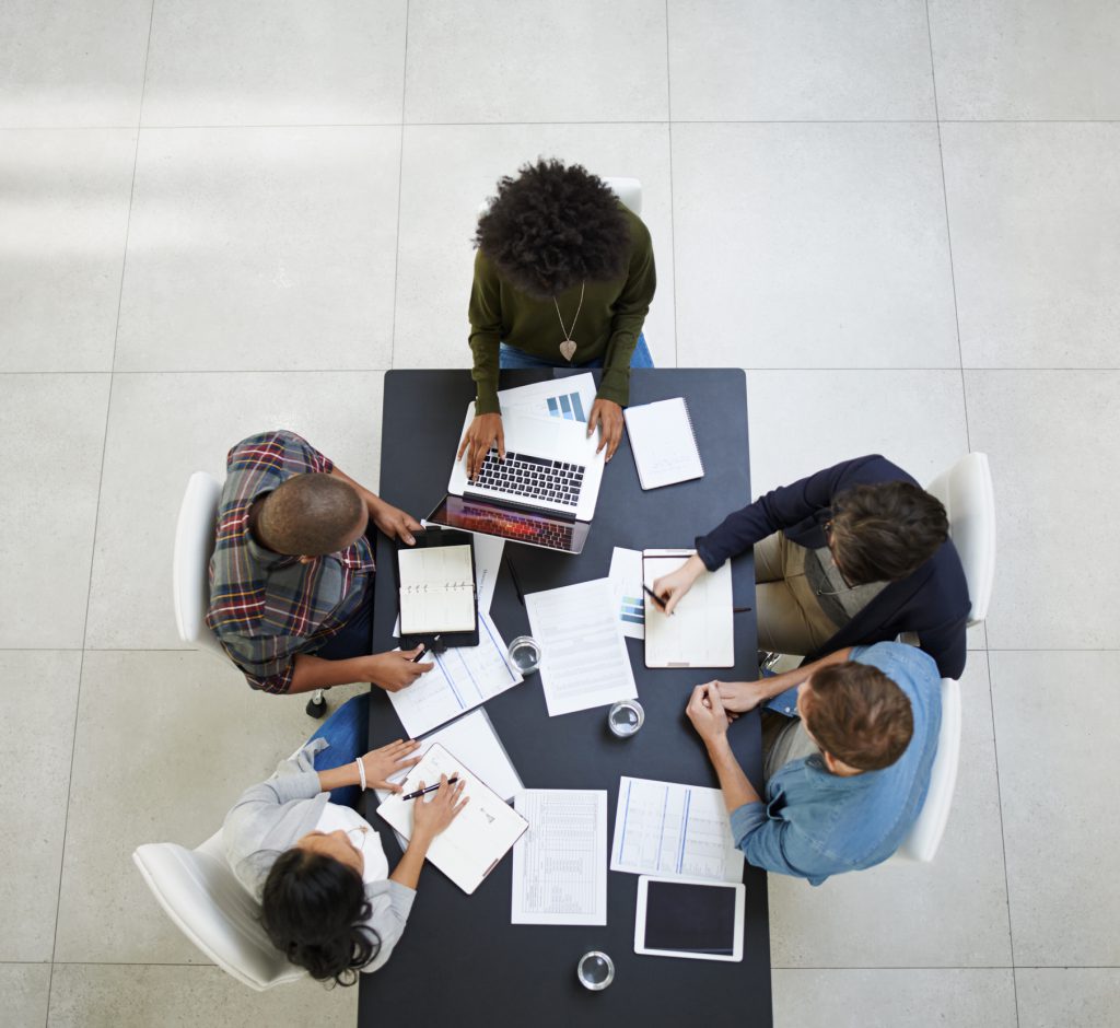 Diverse team of women and men sitting around a table